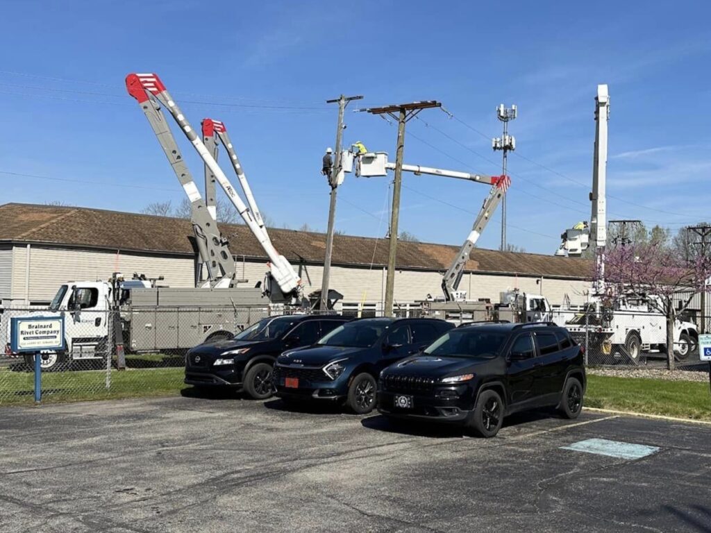 Bucket trucks outside Brainard Rivet to work on substation.