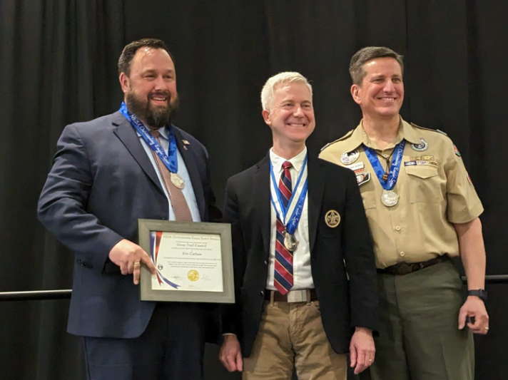 Eric Carlson holding his award