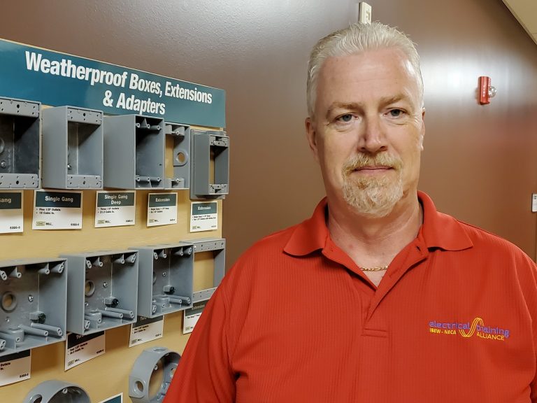 Eric Davis of the Warren Electrical JATC stands near equipment installed by apprentices.