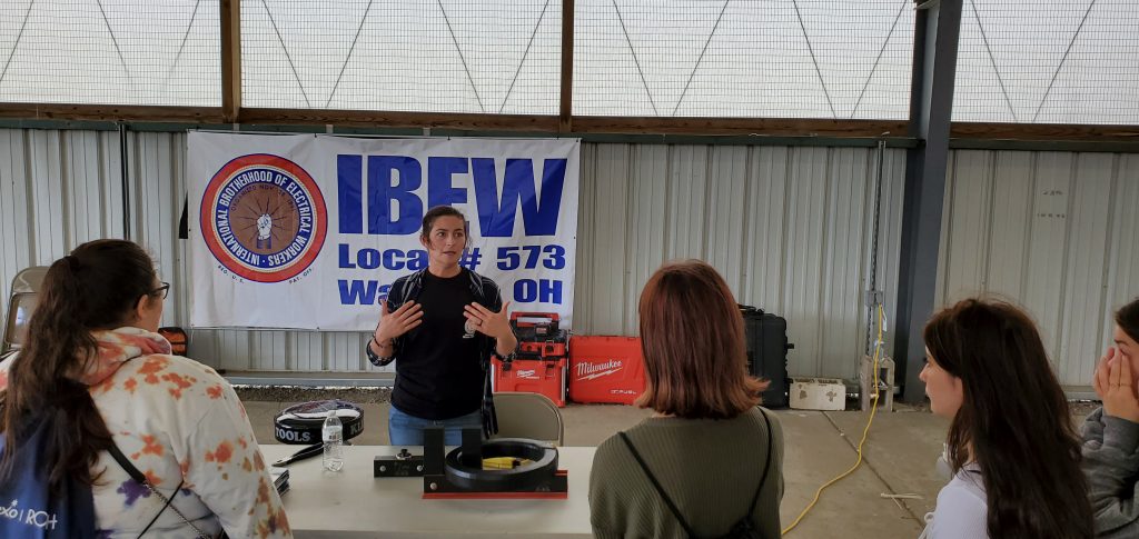 An apprentice talks with high school students about joining trades.
