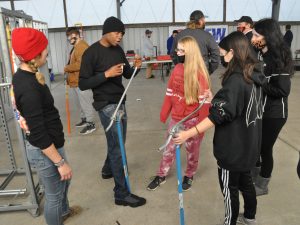 An electrical journeyman shows high school students how to bend conduit.