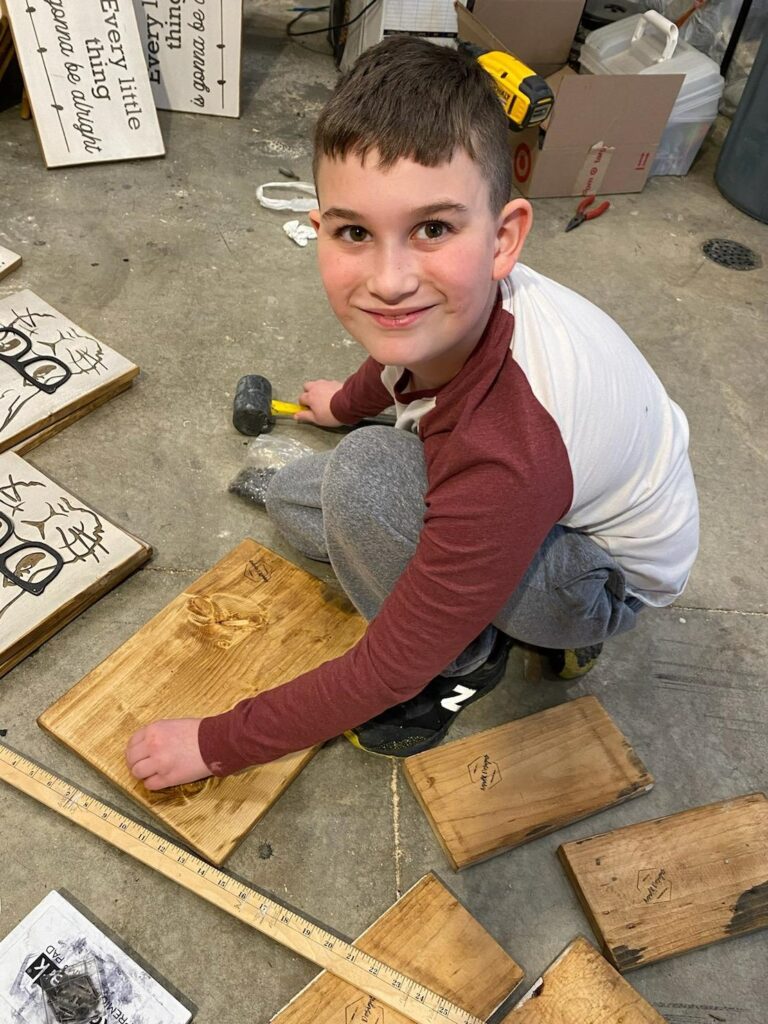 Austin Lucas, 9, works on a sign for his family business, A and R Design.