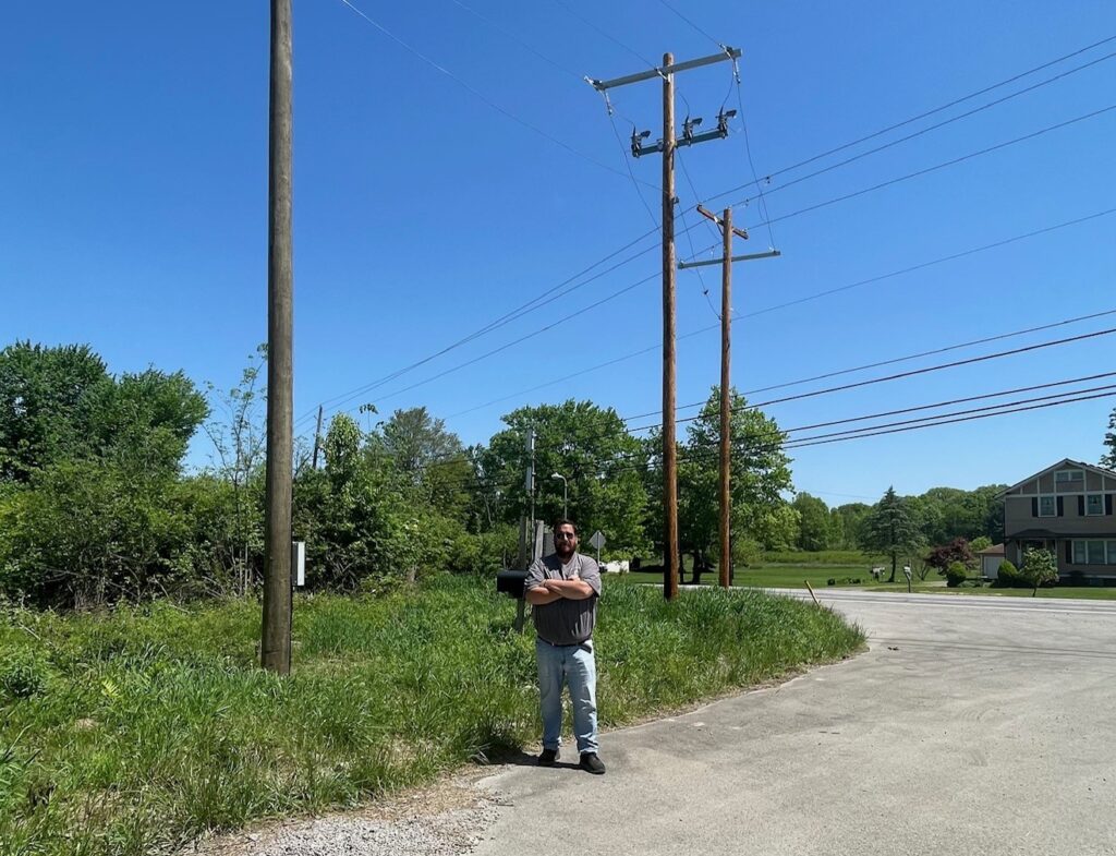 Jason Rubin, president of CR Electric, standing in front of power poles at the entrance to the Copper Ridge injection well in Vienna.