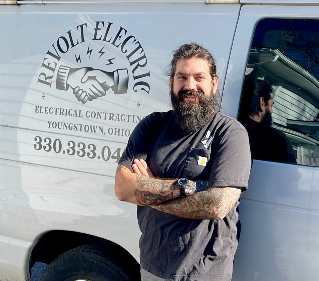 Sam Decesare, owner of Revolt Electric, outside his work van.